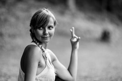 Thoughtful young woman gesturing ok sign at park