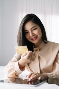 Portrait of young woman using mobile phone at home