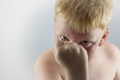 Close-up of shirtless boy against white background