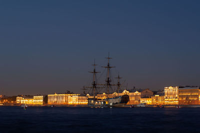 Sailboats in sea against clear sky at night