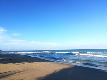 Scenic view of beach against blue sky