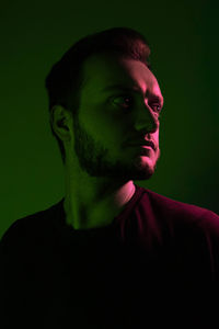 Portrait of young man against black background