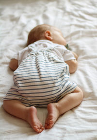 High angle view of baby sleeping on bed