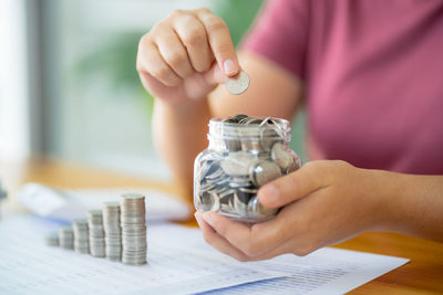 Midsection of man holding coin in office