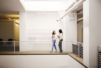 Businesswomen talking while walking in corridor