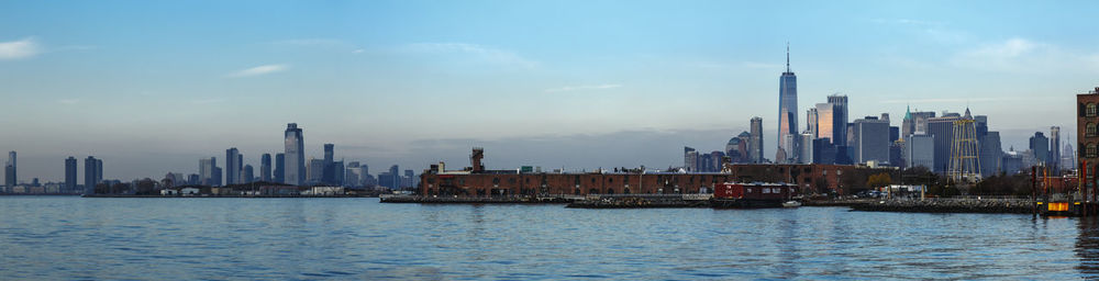 Buildings by sea against sky