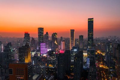 Illuminated buildings against sky during sunset