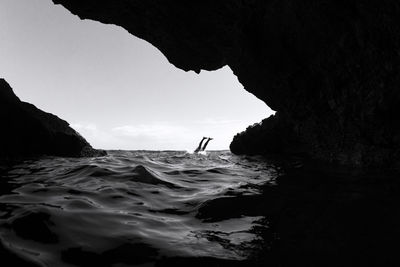 Silhouette of one person jumping to sea