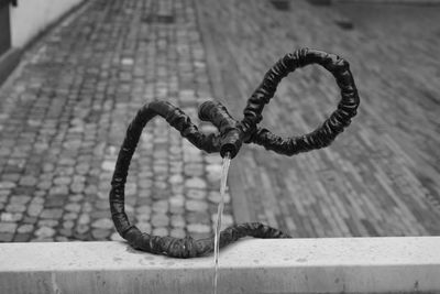 Close-up of water flowing through pipe on footpath