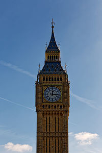 Low angle view of clock tower against blue sky