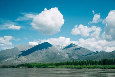 Lake and mountains against cloudy sky