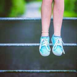 Low section of girl standing on railing