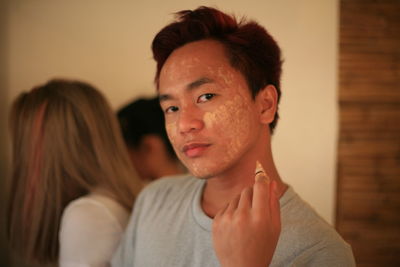 Portrait of man applying beauty product on face at home