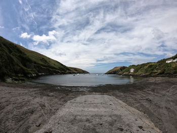 Scenic view of road by mountains against sky