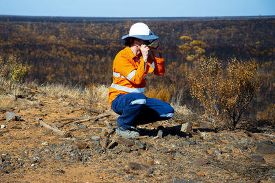 Side view of man crouching on field