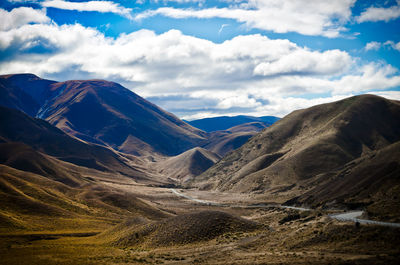 Scenic view of mountain range against cloudy sky