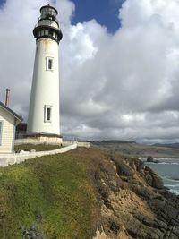 Lighthouse on beach against sky