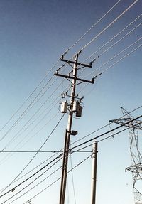 Low angle view of electricity pylon against clear sky