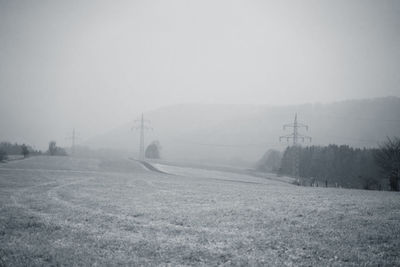Scenic view of field against sky during foggy weather