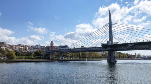 View of bridge over river against cloudy sky