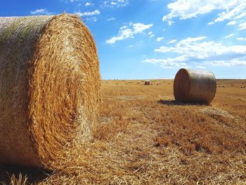 Hay bales on field against sky