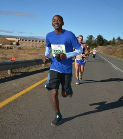 Full length of young man running on road