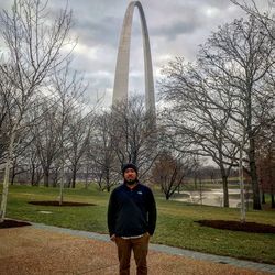 Full length of man standing by bare tree against sky