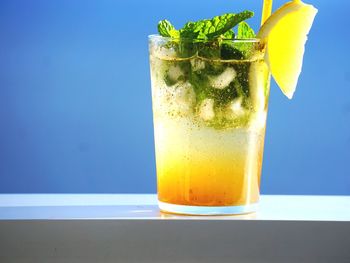 Close-up of drink on railing against sea