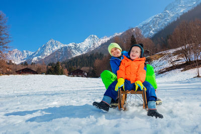 Portrait of man sitting on snow covered mountain