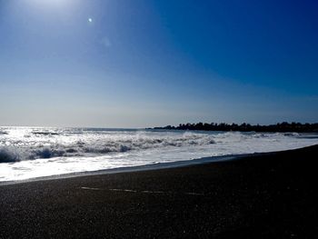 Scenic view of beach against clear blue sky