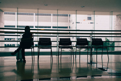 Woman sitting on chair at airport