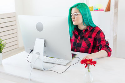 Low angle view of girl using laptop on table