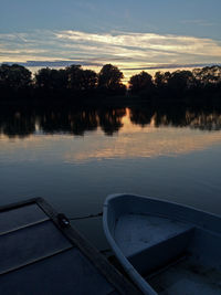 Reflection of trees in water at sunset