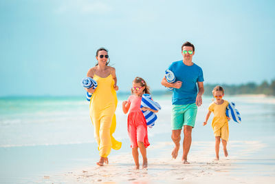 Full length of family standing at beach