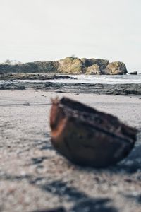 Surface level of rocks on beach against clear sky