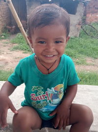 Portrait of cute smiling girl sitting outdoors
