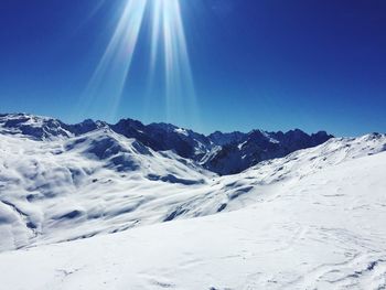 Scenic view of snowcapped mountains against clear blue sky