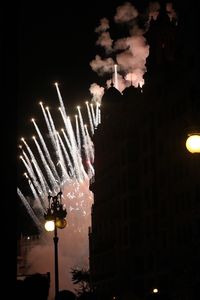 Low angle view of illuminated street lights against sky at night