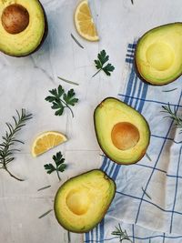 Fresh avocado with herbs and lemons lies on the table on white background. flat lay. top view.