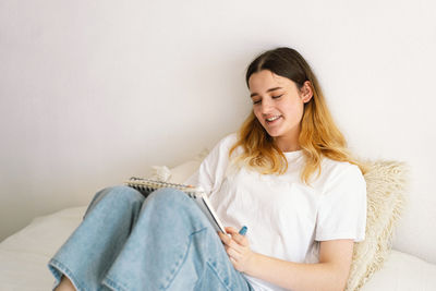 A teenage girl is drawing or doing homework in the bedroom. a teenager studies at home.