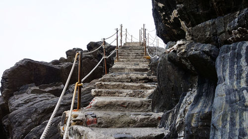 Low angle view of steps on cliff against sky
