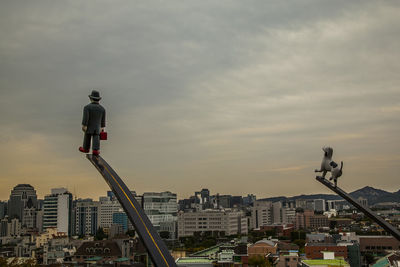 View of cityscape against cloudy sky