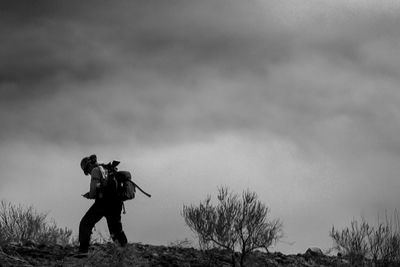 Low angle view of man standing on field against sky