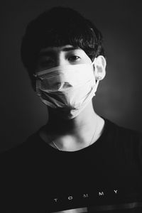 Close-up portrait of young man against black background