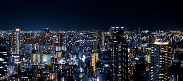 Illuminated cityscape against sky at night