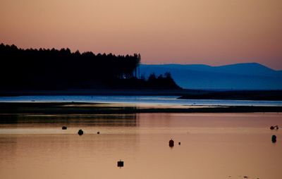 Scenic view of lake against sky at sunset