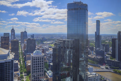 Skyscrapers in city against cloudy sky