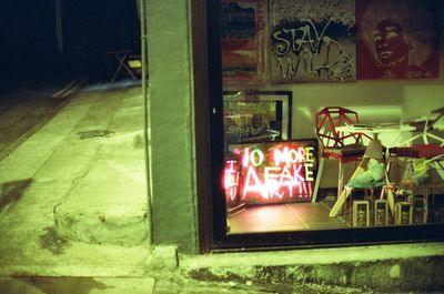 Illuminated text on wall at night