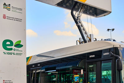 Low angle view of sign board against sky in city