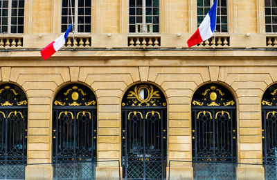 Low angle view of flags hanging against building